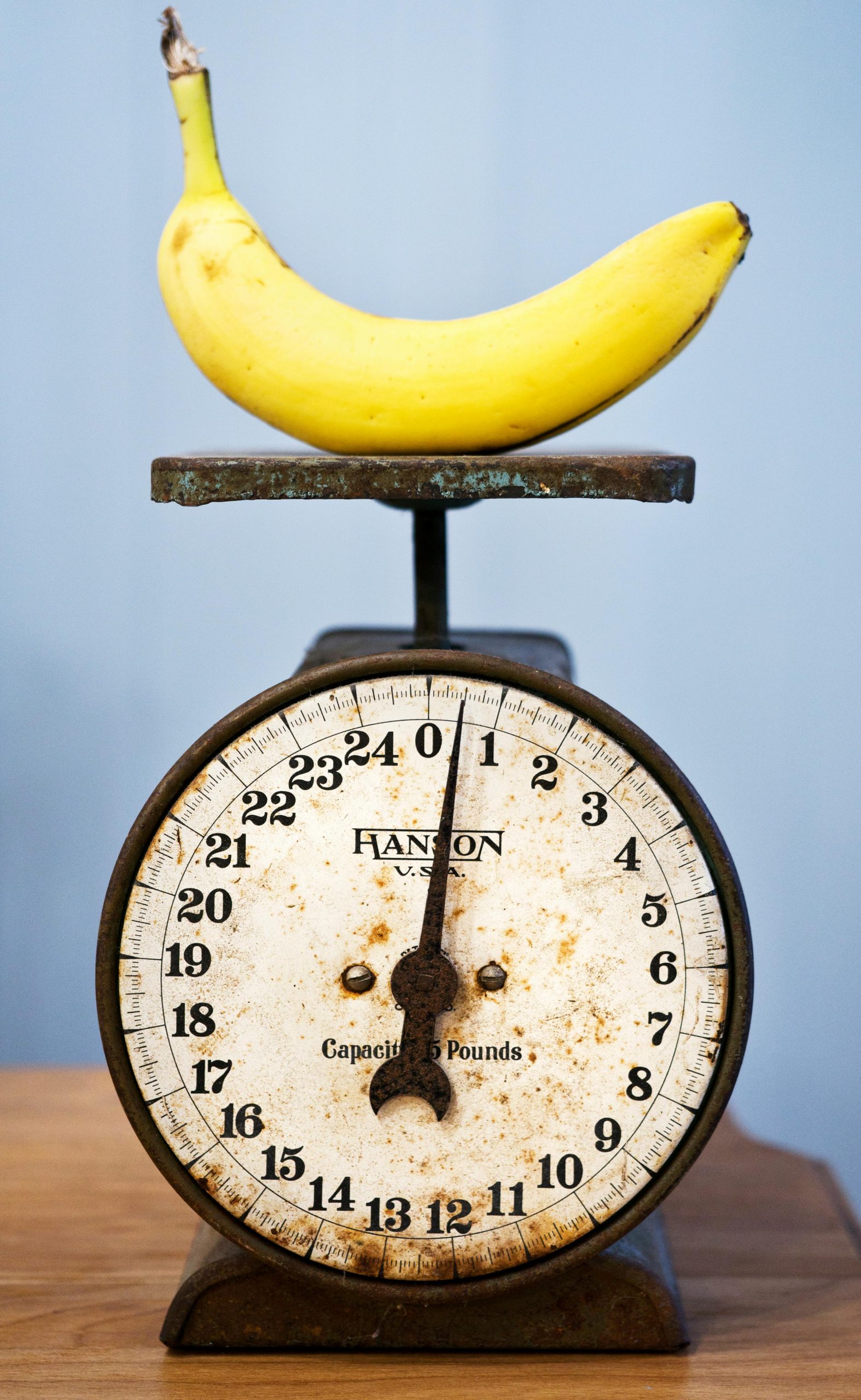 A yellow banana rests on an antique scale, showcasing vintage charm.