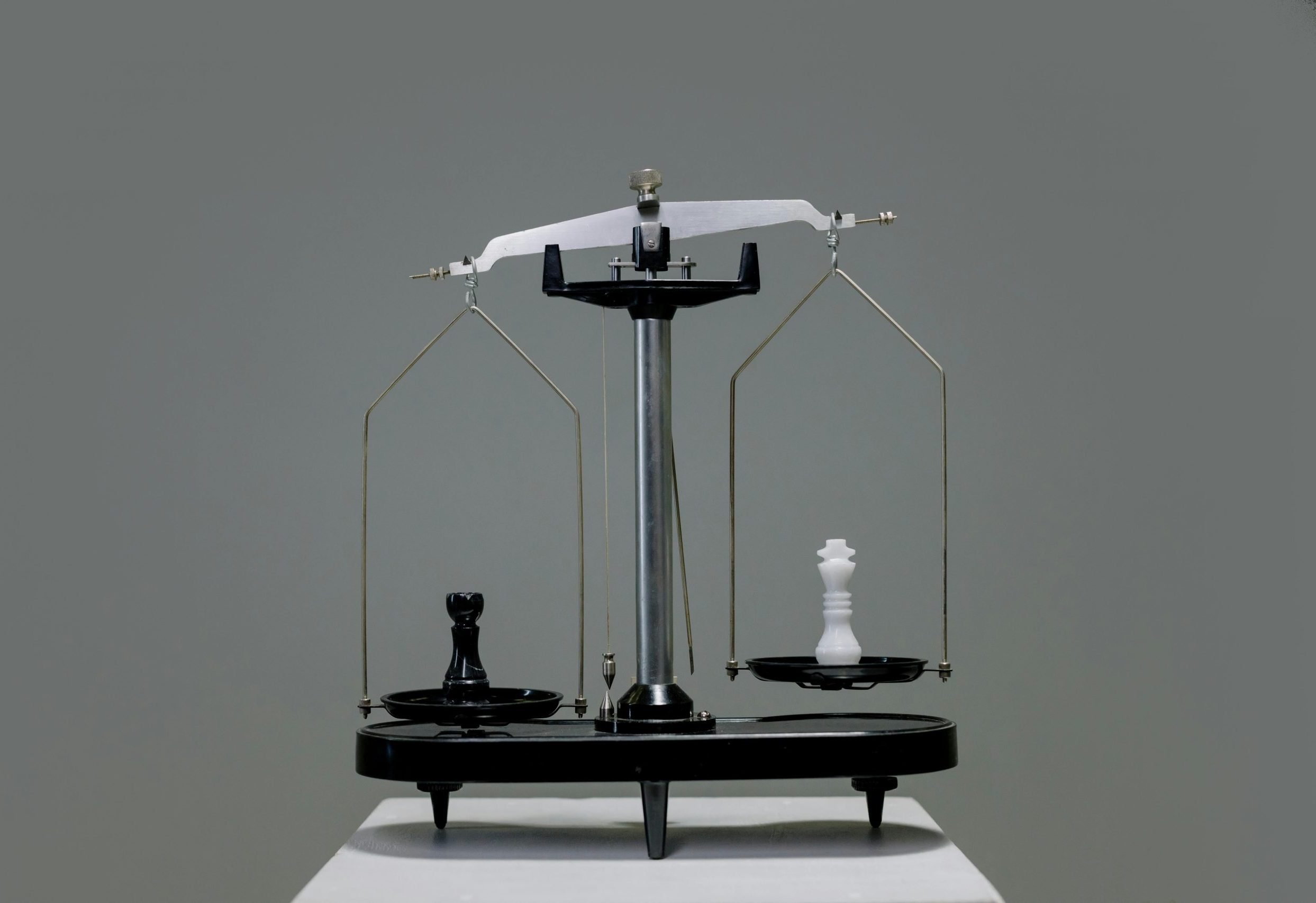 Chess pieces balanced on a scale depicting equality or strategy in decision making.